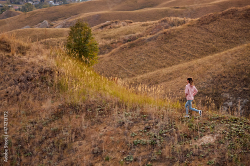 Woman Training  jogging. young sportswoman runs in summer field at sunset. healthy beautiful fit caucasian lady is engaged in fitness  jogging in country in sun. Jogger breathes fresh air on field.