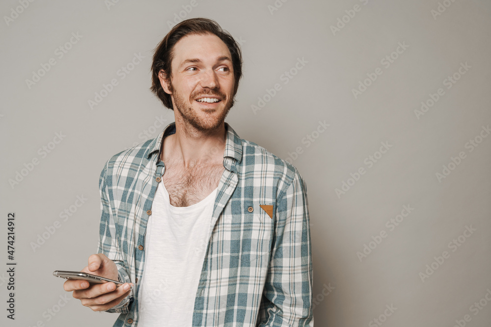 Bristle man dressed in shirt smiling while using cellphone Bristle man dressed in shirt smiling while using cellphone