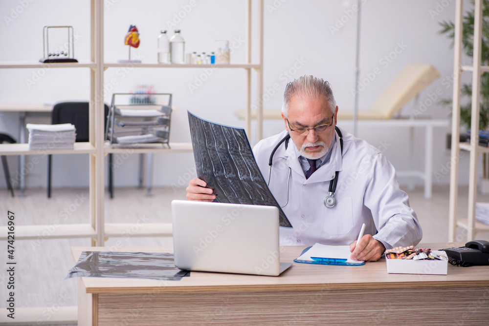 Old male doctor radiologist working in the clinic