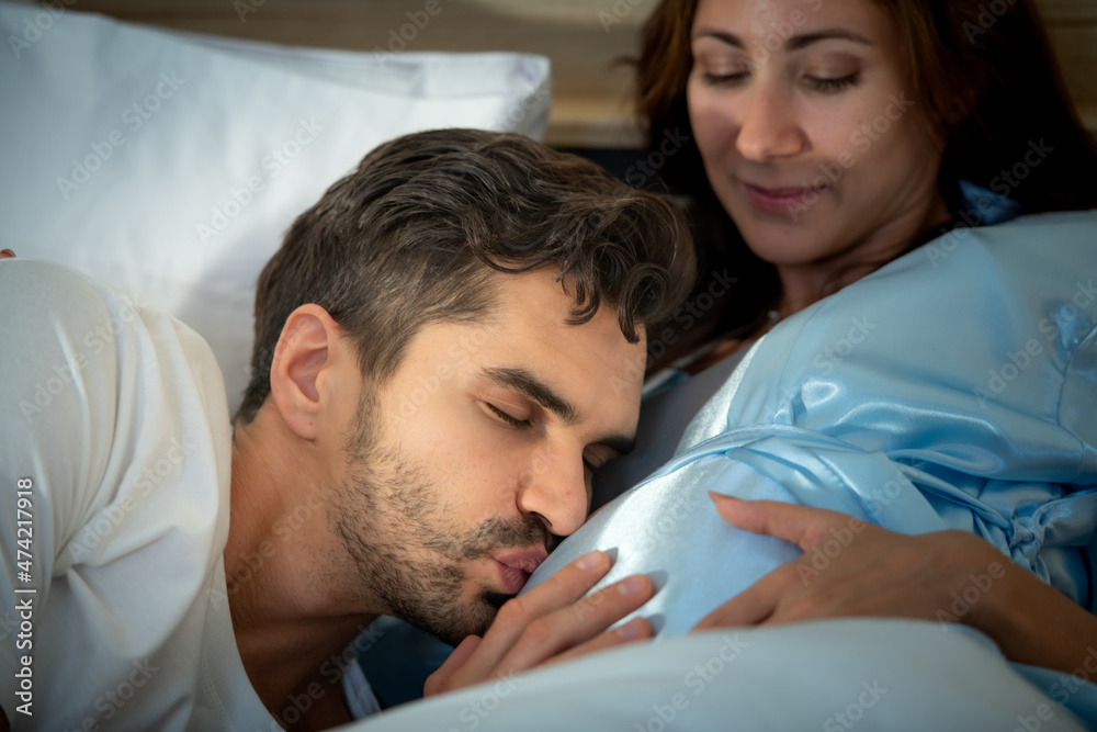 Pregnant woman with husband in bedroom with the atmosphere of having fun talking Pregnant woman with husband in bedroom with the atmosphere of having fun talking