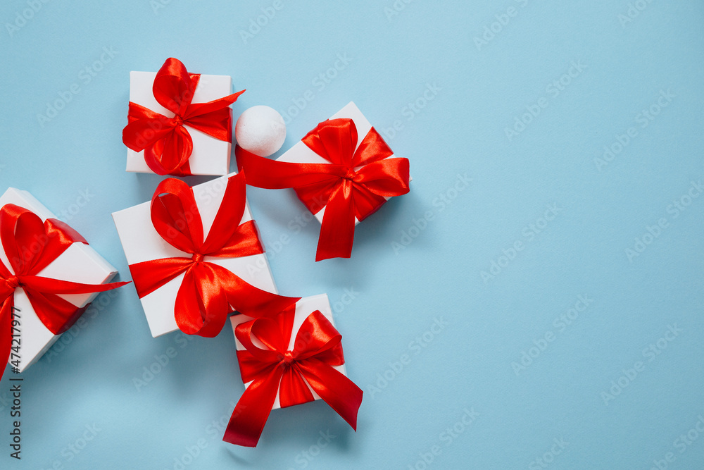 Present boxes on blue background greeting card holidays concept, gift white box tied with red ribbon