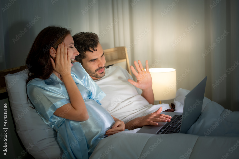 Pregnant woman with husband in bedroom Say hello to friends in social media and update baby in the womb. Pregnant woman with husband in bedroom Say hello to friends in social media and update baby in the womb.