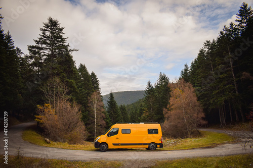 yellow camper van on a curb in the mountains