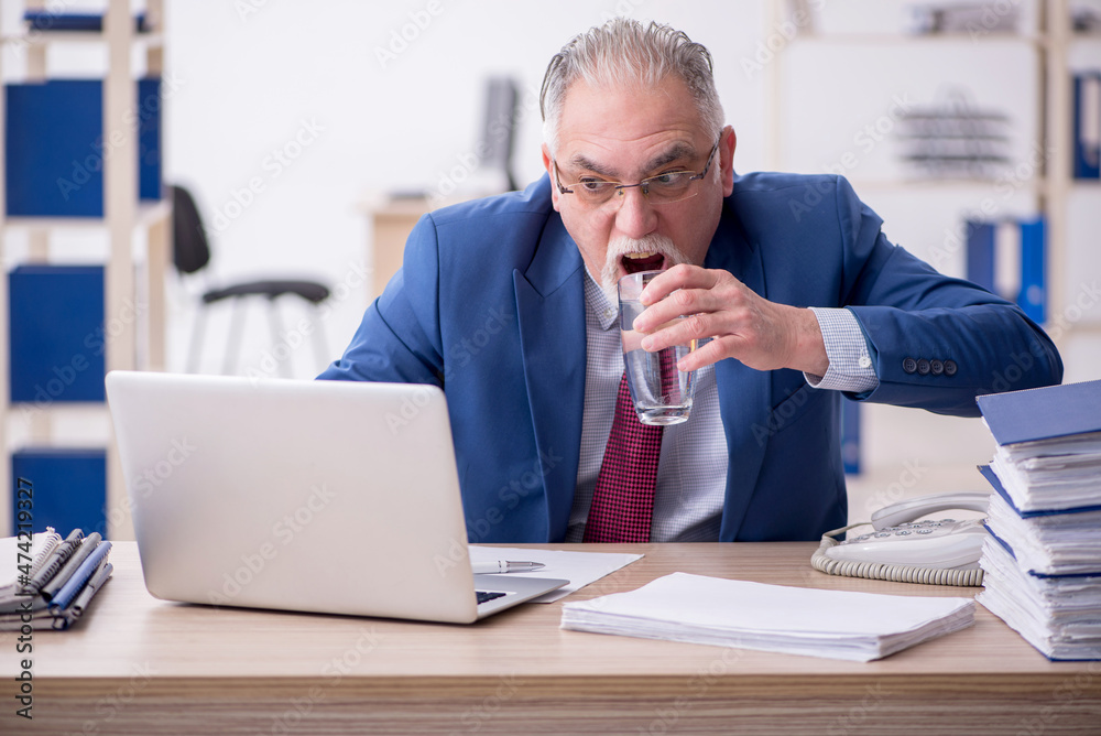 Old male employee and too much work in the office Old male employee and too much work in the office