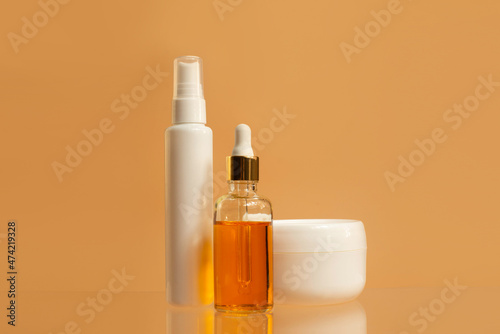 Unbranded bottles in mockup style . Tube of eye oil  daycosmetic serum  cream on beige background.