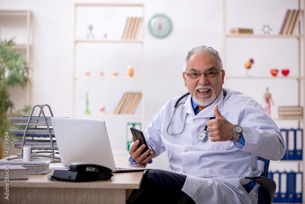 Old male doctor working in the clinic Old male doctor working in the clinic
