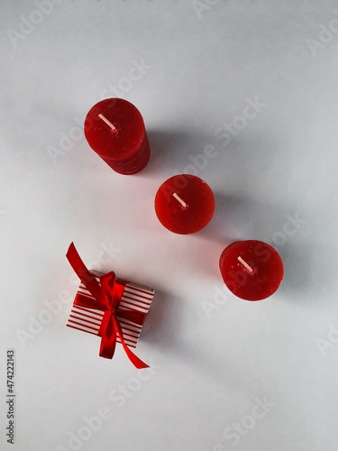 On a white background red Christmas candles, gift. Background for postcards