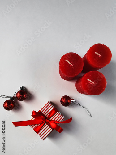 On a white background red Christmas candles, gift. Background for postcards