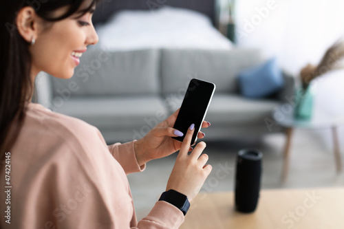 Back view of woman using phone with empty mockup screen photo