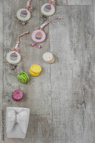 Moscow, Russia, December 2021, background, white cup with wings and multicolored macarons on a light wood background