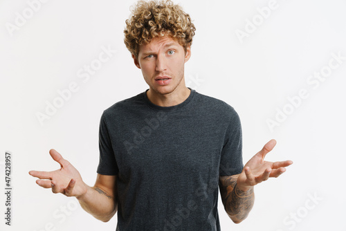 Photography Young perplexed man frowning and gesturing at camera