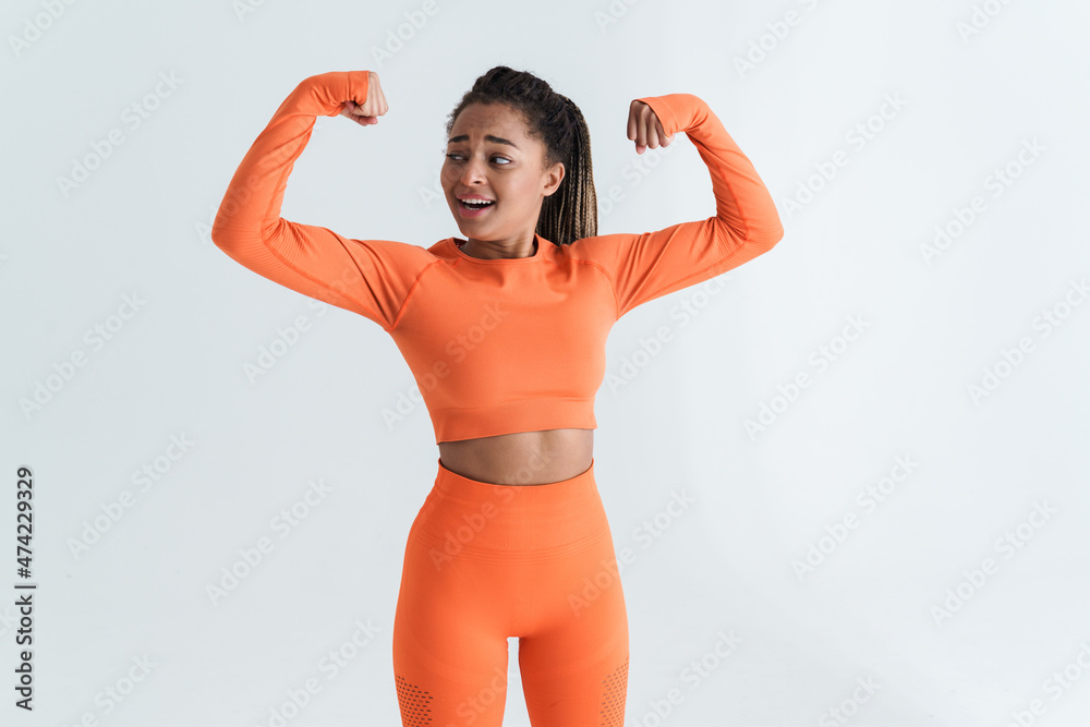 Black young sportswoman with afro pigtails showing her biceps Black young sportswoman with afro pigtails showing her biceps