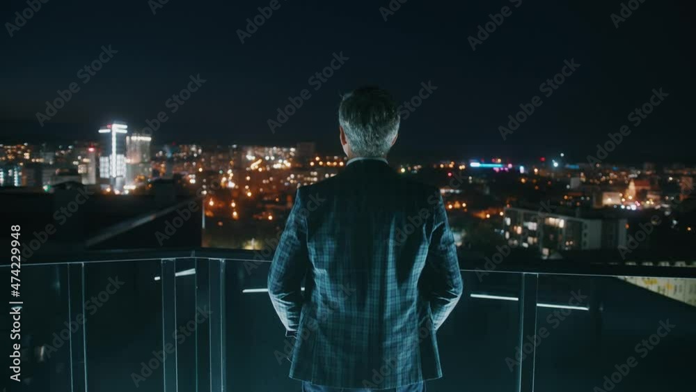 Close up shot back businessman in suit stand on balcony at night. Silhouette. Skyline. Think. Building. Slow motion