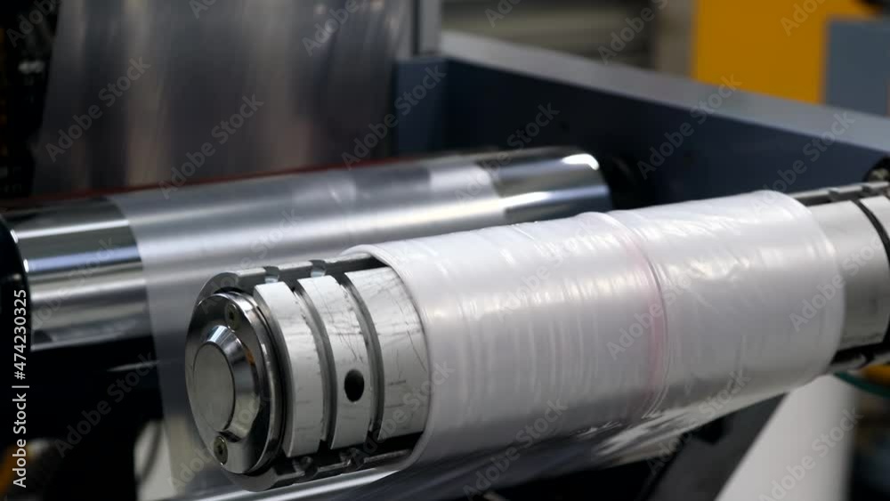 industrial machine with roll of newly produced transparent plastic film industrial machine with roll of newly produced transparent plastic film