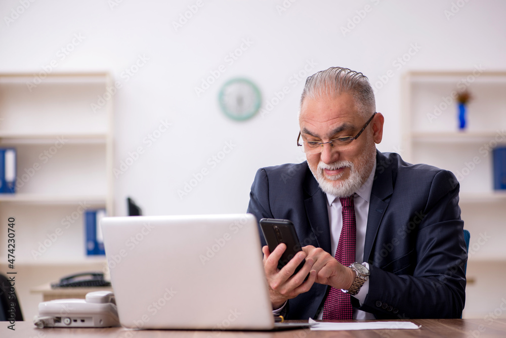Old male employee working in the office Old male employee working in the office