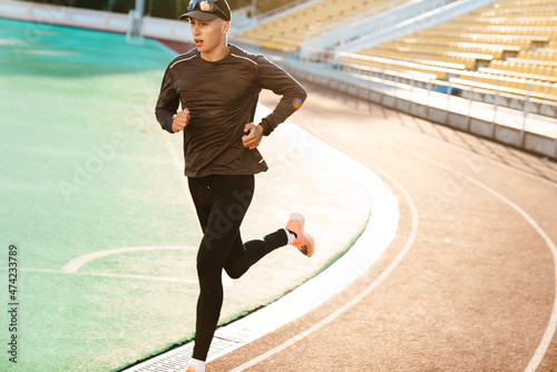 Young white sportsman running while working out on stadium © Drobot Dean