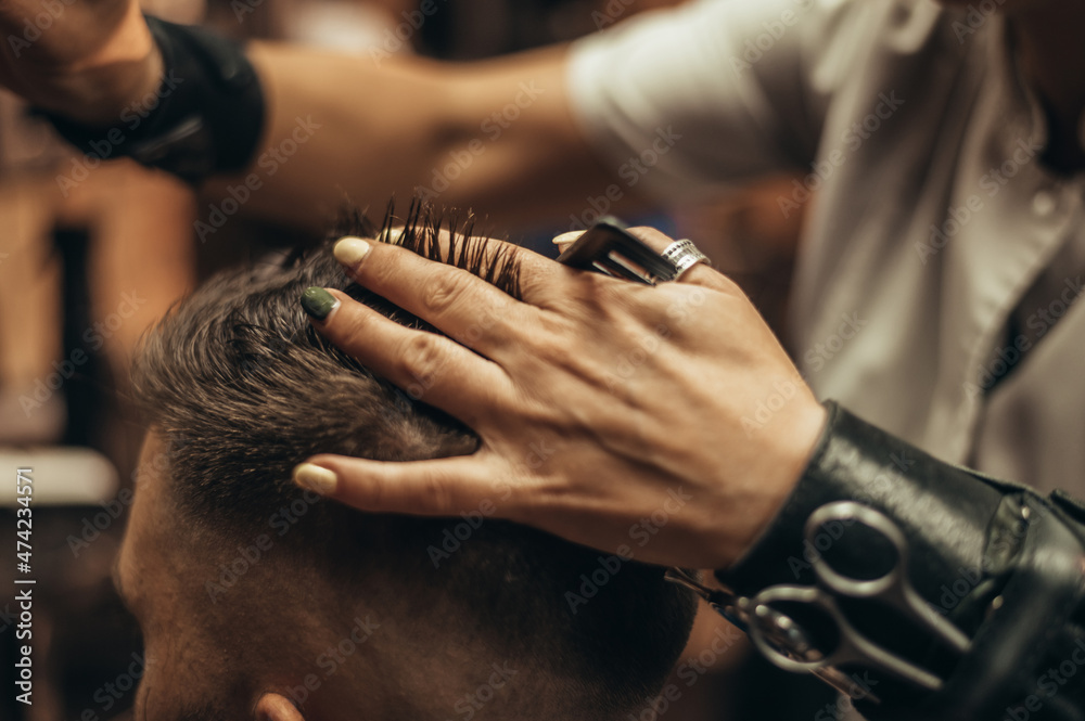 Young man getting haircut by hairdresser