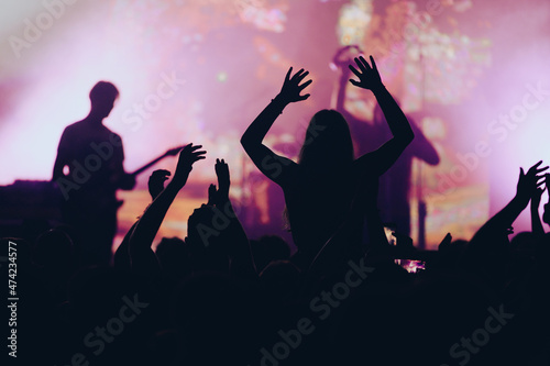 Silhouette of concert crowd in front of bright stage lights on a music festival