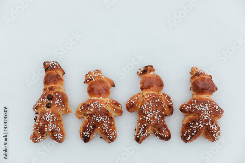 Homemade dough men on snow made with sweet yeast dough and covered with decorative sugar. Swiss tradition to bake dough men  - called in German Grittibänzli - on December 6 and in Advent time.