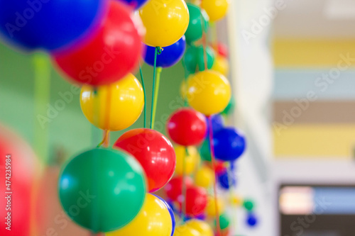 Multi-colored plastic balls hang in the children's room. Close plan
