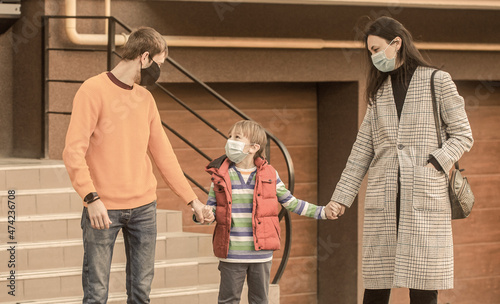 Parents and kid wearing a surgical mask. Air pollution concept. Prevention coronavirus. Coronavirus quarantine. Family going walk. Coronavirus, illness, infection, quarantine, medical masks