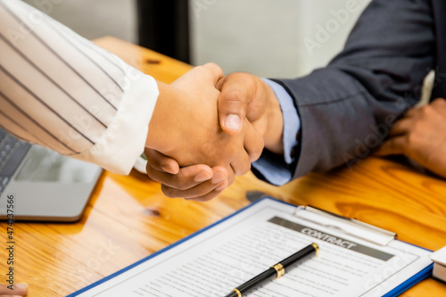 Business negotiations, image of a business man holding a business woman's hand, two happy with his work, they enjoy his colleagues, people gesture handshake concept.