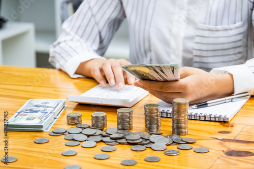 business women holding banknotes and calculating money, women saving money for household expenses Monthly utility bills, family budget calculations, investment or personal savings strategies.