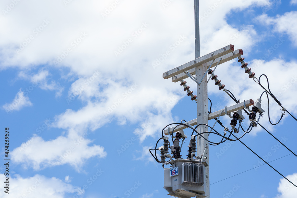 Transformer on high voltage pole with bright sky background