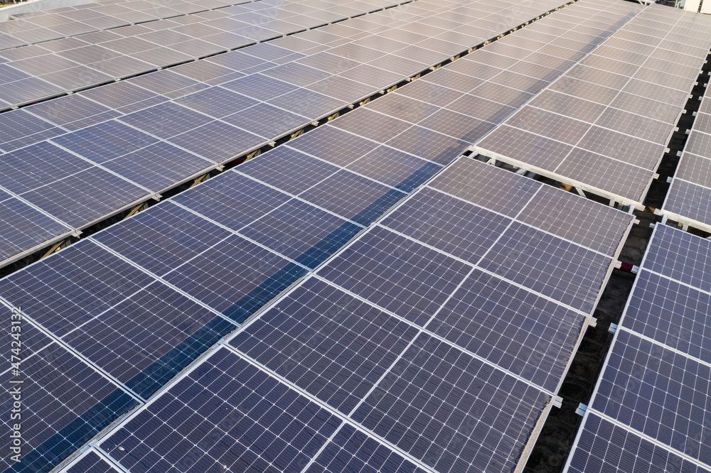 Drone fly over solar panel station in city at roof top building Drone fly over solar panel station in city at roof top building