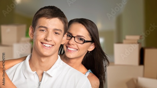 Cheerful lady, showing house key indoors. Lovely couple posing in new apartment