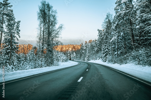 Winter asphalt road.  Winter road and trees with snow and Latvian landscape. Soft focus on photos. © Emvats