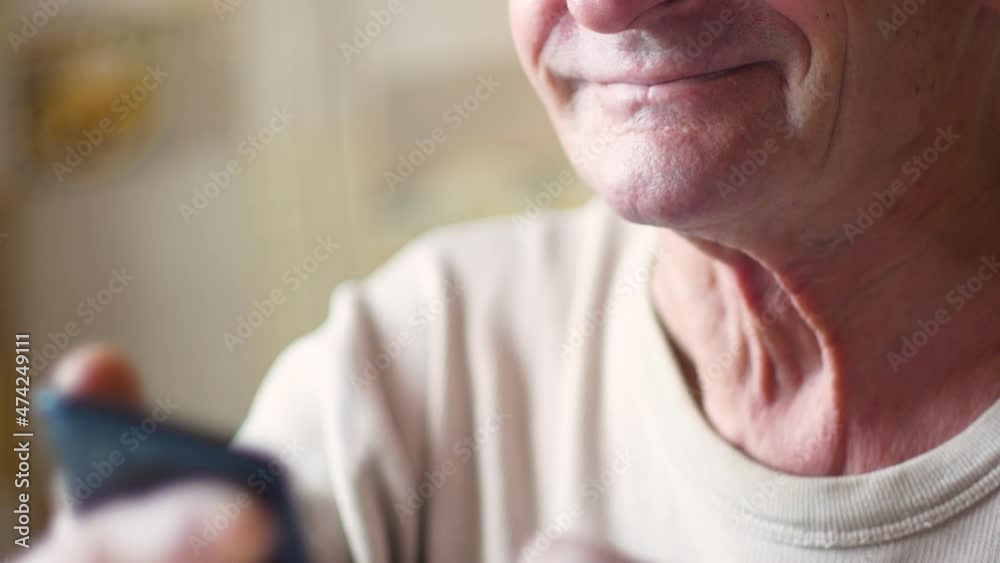 Portrait of a smiling Caucasian elderly man over 70 years old using a smartphone, chatting, browsing the web. Selective focus, low depth of field Portrait of a smiling Caucasian elderly man over 70 years old using a smartphone, chatting, browsing the web. Selective focus, low depth of field