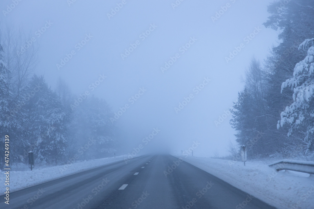 Foggy road in the evening. Winter asphalt road blurred. Blurred photo Foggy road in the evening. Winter asphalt road blurred. Blurred photo