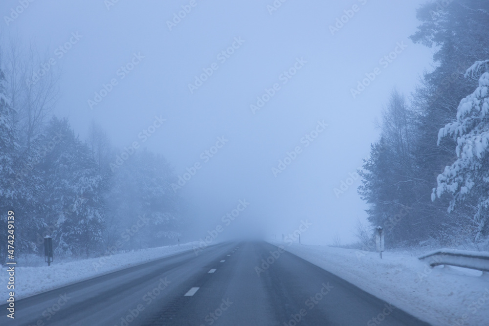 Foggy road in the evening. Winter asphalt road blurred. Blurred photo