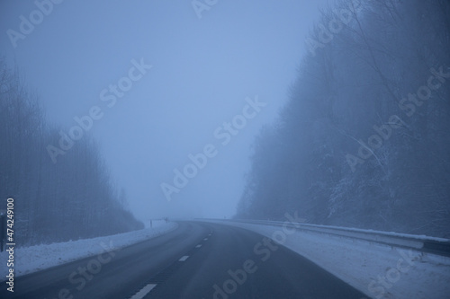 Foggy road in the evening. Winter asphalt road blurred. Blurred photo