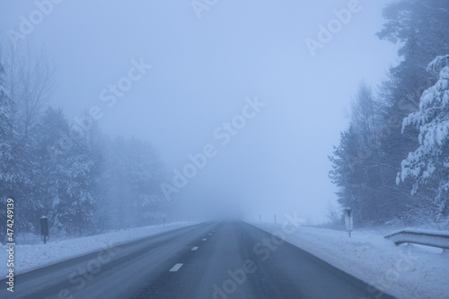 Foggy road in the evening. Winter asphalt road blurred. Blurred photo © Emvats