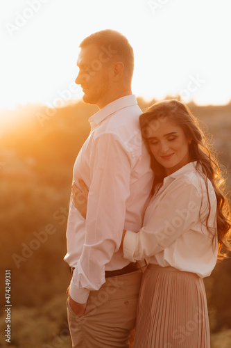 Loving wedding couple outdoor in the rays of the sunset