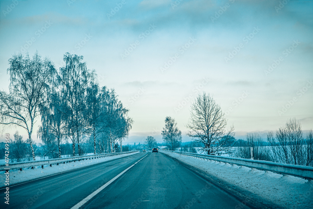 Obraz premium Winter asphalt road. Winter road and trees with snow and Latvian landscape. Soft focus on photos.