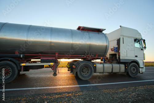 Petrol cargo truck driving on highway hauling oil products. Delivery transportation and logistics concept