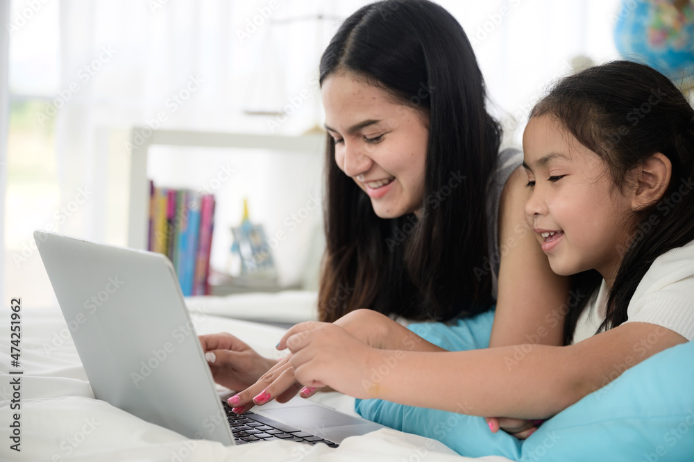 child girl person 2 sisters watching media and learning on laptop, online communication at home child girl person 2 sisters watching media and learning on laptop, online communication at home
