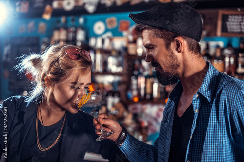 Professional woman tapster creates a cocktail in the nightclub photo