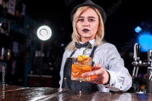 Girl bartender creates a cocktail on the alehouse photo