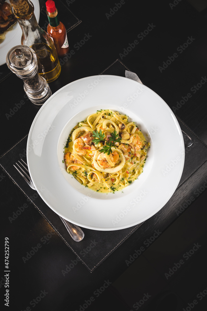 Perfect Seafood Menu Dish Plate Food Octopus Salmon, Shrimp Risotto Pasta Vegetables Salad Fish on a Dark Background Perfect Seafood Menu Dish Plate Food Octopus Salmon, Shrimp Risotto Pasta Vegetables Salad Fish on a Dark Background