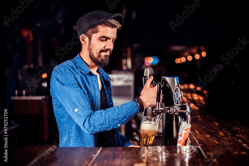 Professional tapster makes a show creating a cocktail at bar photo
