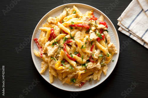 Homemade One Pot Chicken Fajita Pasta on a Plate on a black background, top view. Flat lay, overhead, from above.