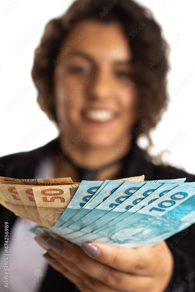 Brazilian woman is dealing with money from Brazil. Person offering money and smiling Isolated on white background. Brazilian woman is dealing with money from Brazil. Person offering money and smiling Isolated on white background.