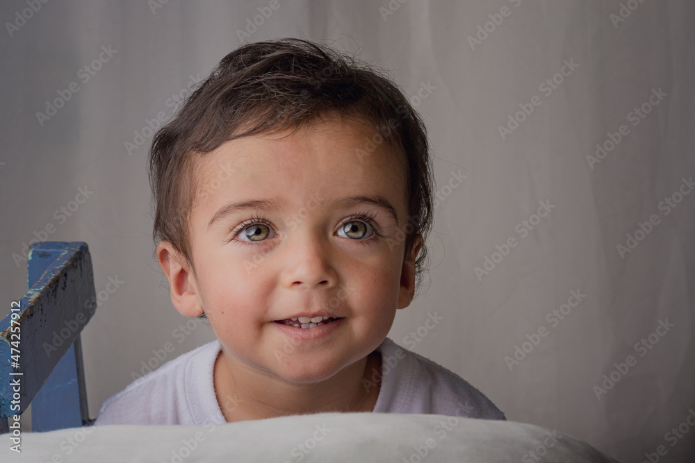 portrait of little boy on a white pillow smiling and imagining portrait of little boy on a white pillow smiling and imagining