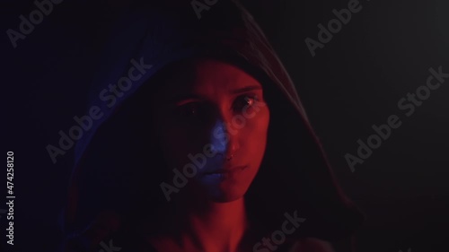 Portrait of a woman putting on the hood with a deep look. Dolly shot