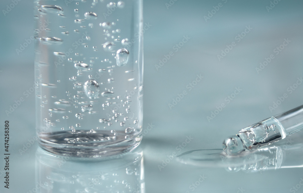 Pipette with fluid hyaluronic acid on blue background. Cosmetics and healthcare concept closeup. Dose of serum or retinol with air bubbles. Flat lay. Luxury gel or beauty product presentation in macro Pipette with fluid hyaluronic acid on blue background. Cosmetics and healthcare concept closeup. Dose of serum or retinol with air bubbles. Flat lay. Luxury gel or beauty product presentation in macro