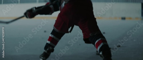 MED Professional ice hockey player practices his slap shots on the indoor rink alone. Shot with 2x anamorphic lens photo